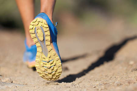 Athlete running sport feet on trail, selective focus on sole.Training workout on off road trail...