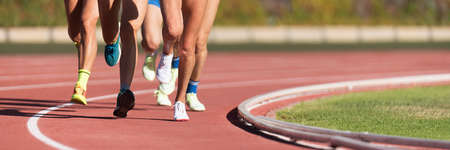 Athletics people running on the track field. Running a race on a track for sports competition and winningの写真素材