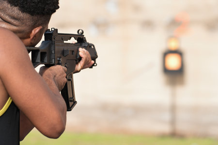 Man holding a black rifle to target shooting at a shooting range with an automatic weaponの写真素材