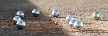Petanque balls boules bowls on closeup on sand gravel court background, game of petanque on the ground. Balls and a small wood jackの写真素材