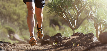 Trail running athlete exercising for fitness and health outdoors on mountain pathway, closeup of...