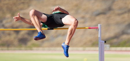 High jump athletics, high jump male athlete successful attempt over barの写真素材