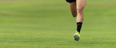 Man running along the grass in sports shoesの写真素材