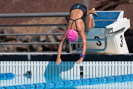 The swimmer jumps from the start block at the start of the race