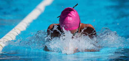 Man swims the breaststroke in the swimming pool