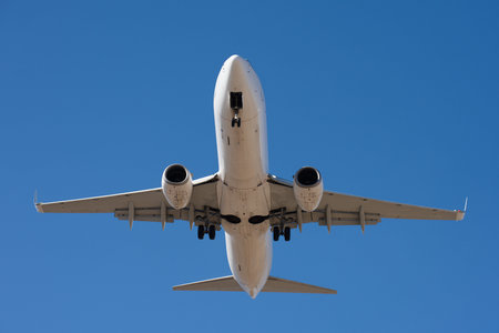 The plane lands. Airplane, passengers flying in the blue sky, preparing to land at the airport. View...