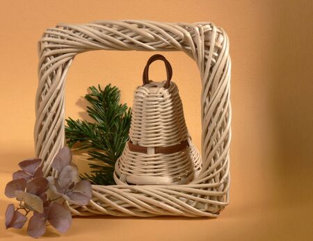Still life with one wicker Christmas bell on orange backgroundの写真素材