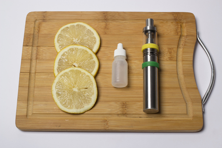 Vaping device with lemon on kitchen boardの写真素材