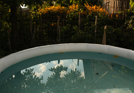 Inflatable swimming pool. Sunset in Garden. End of summer seasonの写真素材