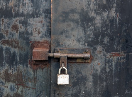 Old rusty locked metal gate. Urban backgroundの写真素材