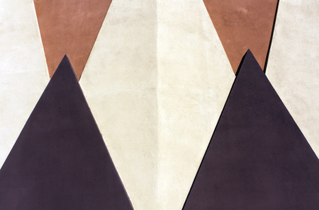 Geometrical figures on colorful plaster wall texture. Architectural background.