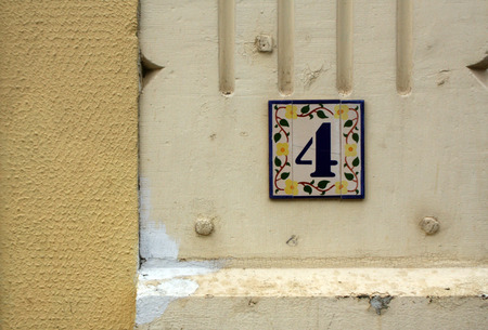 Number four shield on plaster wall. Numbers and figures.の写真素材