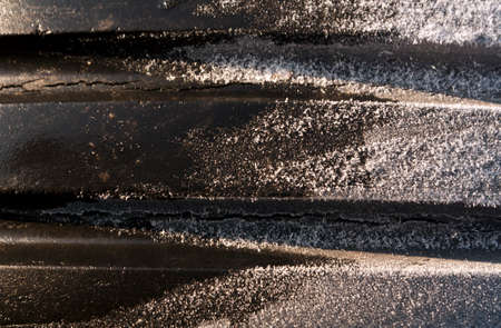 Ice frost on old tyre. Seasonal background