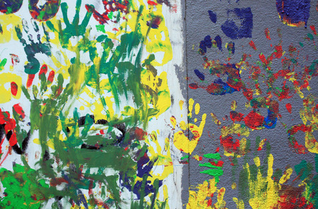 Color hand prints on plaster wall. Background and texture.の写真素材