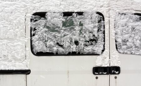 Snow on white car. Seasonal background and texture.の写真素材