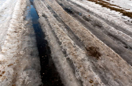 Dirty snow on asphalt road. Seasonal background.の写真素材