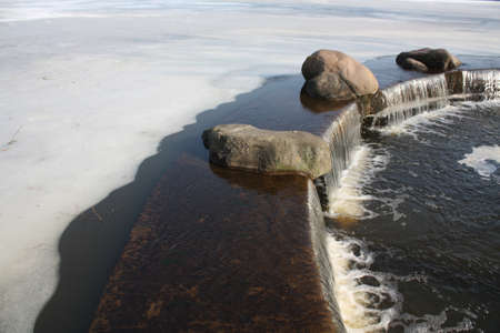 Small waterfall in winter. Seasonal natural background.