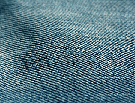 Color jeans textile texture close-up with blur effect. Background and texture for design.