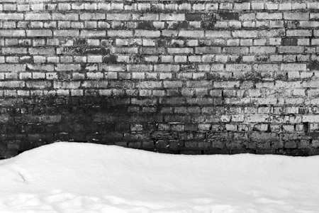 Grungy brick wall texture and pile of snow in black and white. abstract seasonal backgroundの写真素材