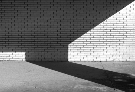 Black and white brick wall texture and shadow. Architectural background.の写真素材