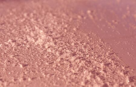 Snow on red metal car surface with blur effect. Abstract background and texture for designの写真素材