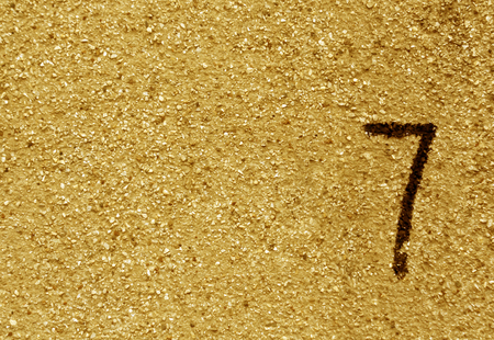 Number seven on orange grunge wall surface.   Abstract background and texture for design.の写真素材