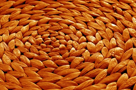 Round straw mat texture in orange color. Abstract background and texture for design.