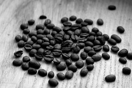 Coffee beans on wooden board with blur effect in black and white. Food and ingredientes.の写真素材