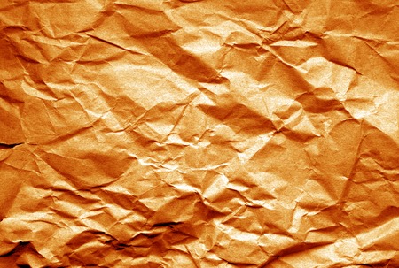Old paper with wrinckles in orange tone. Abstract background and texture for design.の写真素材