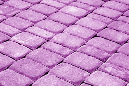 Cobble stone pavement in purple tone. Abstract background and texture for design.