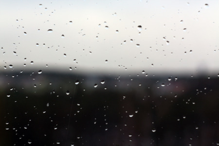 Rain drops on window with blured background. Seasonal background texture for design.