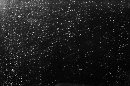 Rain drops on window with blured background in black and white. Seasonal background texture for design.の写真素材