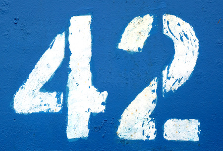 Number 42 in stencil on rusty navy blue metal wall. Abstract background and texture for design.の写真素材