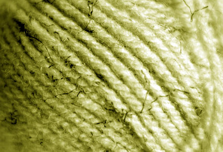 Yarn ball close-up with blur effect in yellow color. Abstract background and texture for design.