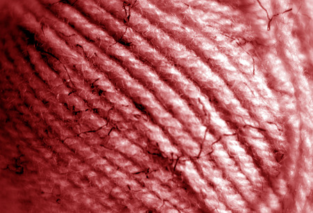 Yarn ball close-up with blur effect in red color. Abstract background and texture for design.