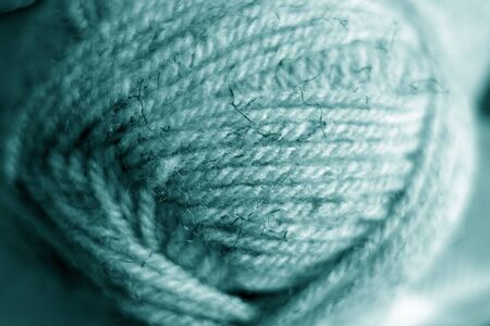 Yarn ball close-up with blur effect in cyan tone. Abstract background and texture for design.の写真素材