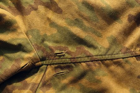 Old military camouflage cloth with holes. Abstract background and texture for design abd ideas.