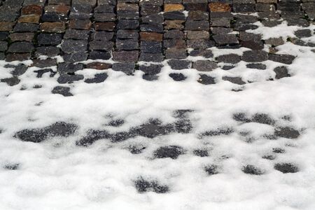 Snow on old stone pavement. Seasonal background for wallpaper or design.の写真素材