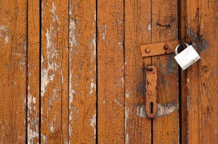 Grungy wooden door with lock. Abstract architectural background and texture for design.の写真素材