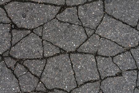 Damaged asphalt surface. Abstract background and texture for design.の写真素材