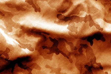 Military uniform pattern with blur effect in orange tone. Abstract background and texture.の写真素材
