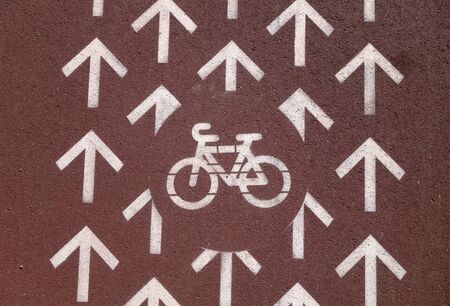 Bicycle path on stone pavement in city. Signs and symbols in urban area.