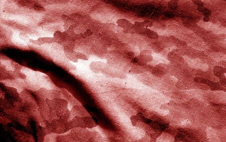 Part of military camouflage uniform close-up with blur effect in red tone. Abstract background and texture for design abd ideas.の写真素材