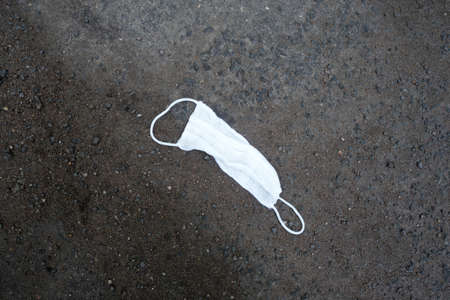 Used medical mask laying on ground. Background for conceptsの写真素材