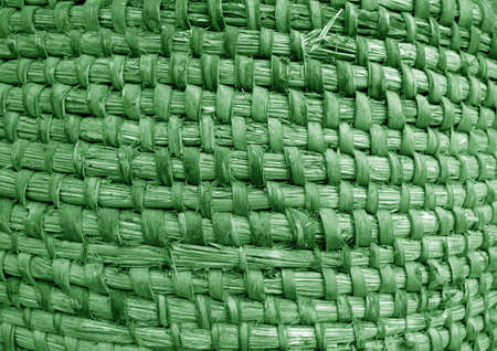 Old hand crafted basket made from dry grass in green tone. Background and texture.の写真素材