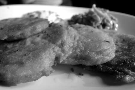 Potato pancakes with salmon and sour cream in black and white. Food background.の写真素材