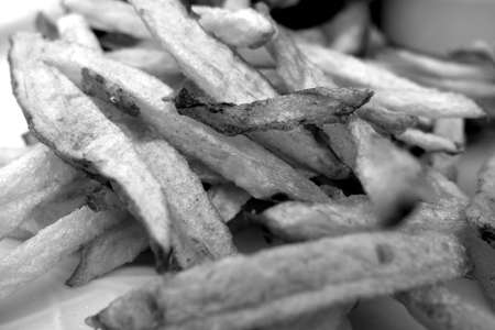Fried potato close-up with blur effect in black and white. Fast food background.