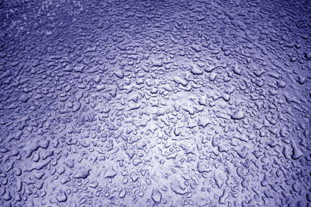 Water drops on metal surface in blue tone. Abstract background and texture for design.