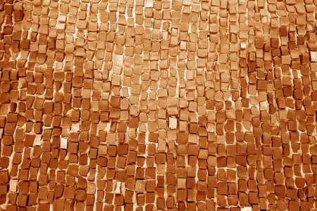 Mosaic wall texture in orange color. Abstract architectural background and texture for design.
