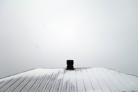 House roof with chimney covered with snow. Architectural backgroundの写真素材